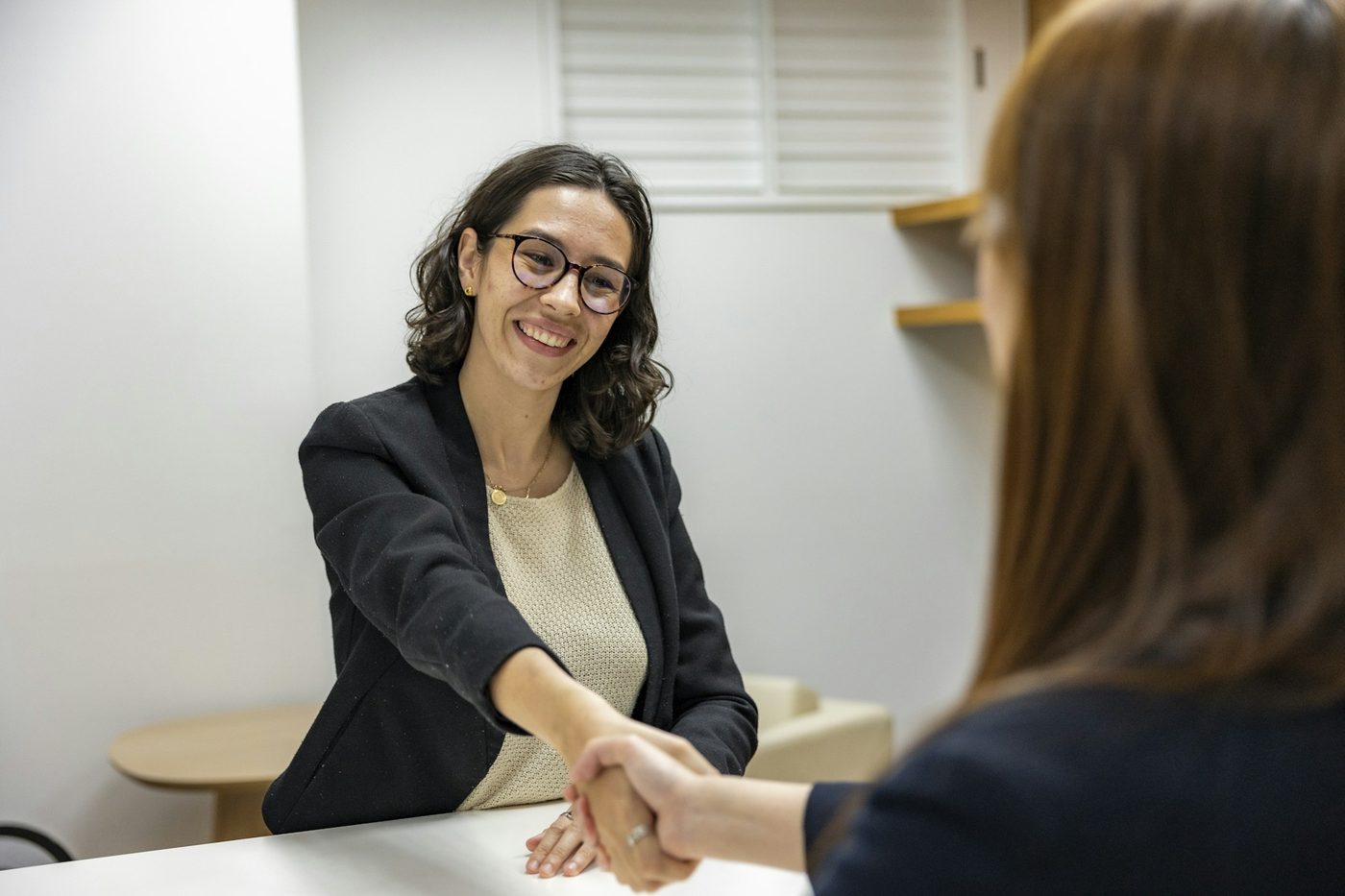 Duas profissionais se cumprimentam durante uma conversa de trabalho